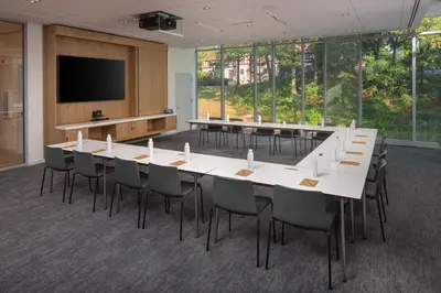 a conference room with a large white table and chairs at The Heartwood in Poughkeepsie