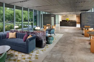 a lobby with a couch and tables and windows at The Heartwood in Poughkeepsie