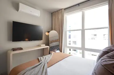 a bedroom with a tv and a bed and a window at Hyatus Luxury Residences Stamford in Stamford
