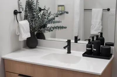 a bathroom counter with a sink and a mirror at Hyatus Luxury Residences Stamford in Stamford