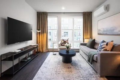 a living room with a couch and a flat screen tv at Hyatus Luxury Residences Stamford in Stamford