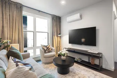 a living room with a couch and a tv at Hyatus Luxury Residences Stamford in Stamford