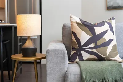 a lamp on a table next to a couch at Hyatus Luxury Residences Stamford in Stamford