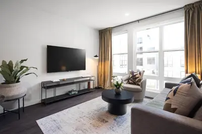 a living room with a couch and a tv at Hyatus Luxury Residences Stamford in Stamford