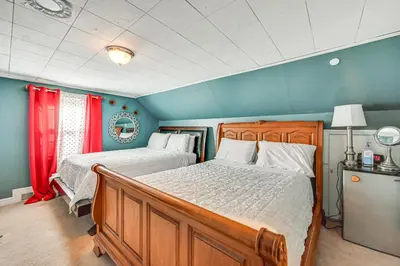 a bedroom with two beds with red curtains at Bring Your Pet and Visit Springfield Westfield Home in Westfield