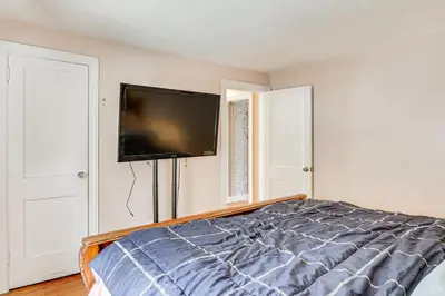 a bedroom with a bed and a flat screen tv on the wall at Bring Your Pet and Visit Springfield Westfield Home in Westfield