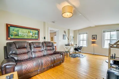 a living room with a leather couch and a desk at Bennington Gem with Smart TV Near Historic District! in Bennington