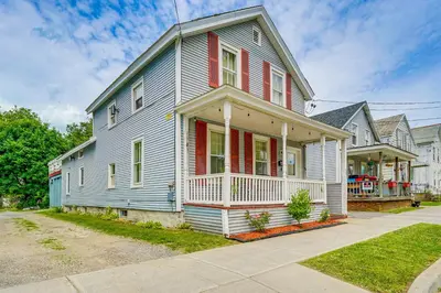a blue house with red shutters on a street at Bennington Gem with Smart TV Near Historic District! in Bennington