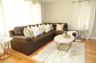 a living room with a brown couch and a table at Grace Filled Apartment in Newark in Newark