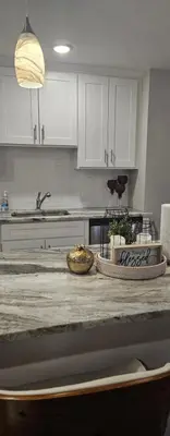a kitchen with white cabinets and a counter top at Grace Filled Apartment in Newark in Newark