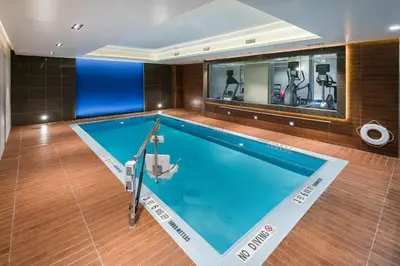 a large swimming pool in a room with a gym at Holiday Inn Brooklyn Downtown by IHG in Brooklyn