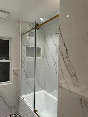 a shower with a glass door in a bathroom at La Casa Bonita Near NYC in Yonkers