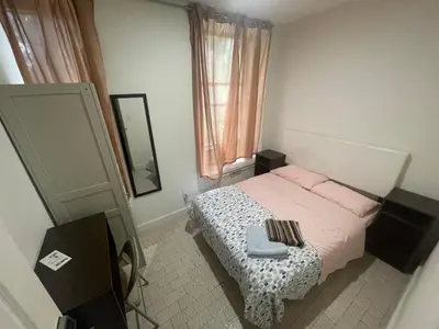 a small bedroom with a bed and a mirror at Hudson Yard 408 in New York