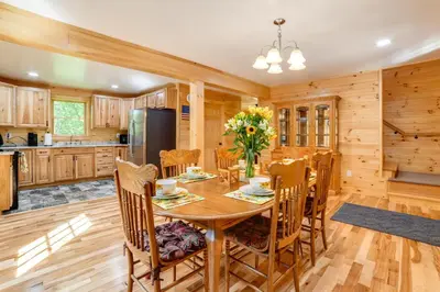 a kitchen and dining room with a wooden table and chairs at Creekside Cabin in Bainbridge with Wraparound Deck! in Sidney