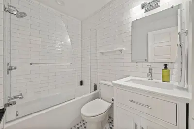 a white bathroom with a toilet and a sink at Upscale Azure by Saratoga Stays in Saratoga Springs