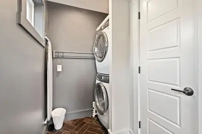 a laundry room with a washer and dryer next to a door at Upscale Azure by Saratoga Stays in Saratoga Springs