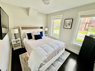a bedroom with a bed and two windows at Upscale Azure by Saratoga Stays in Saratoga Springs