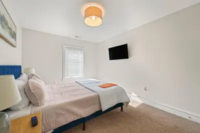 a bedroom with a bed and a flat screen tv at Azure Loft by Saratoga Stays in Saratoga Springs