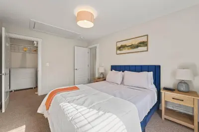 a bedroom with a large bed with a blue headboard at Azure Loft by Saratoga Stays in Saratoga Springs