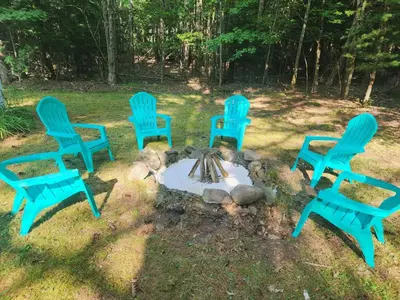 a group of blue chairs around a fire pit at Rustic Catskills Cabin with Hot Tub and Mountain Views in Prattsville