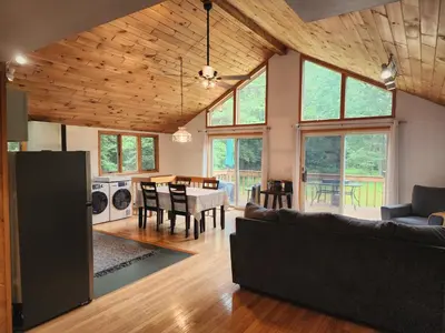 a living room with a couch and a table at Rustic Catskills Cabin with Hot Tub and Mountain Views in Prattsville