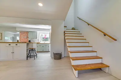 a staircase in a kitchen with white walls and wooden floors at Charming Catskills Getaway Hike, Bike, Sip and More in Acra