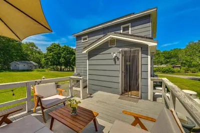 a tiny house on a deck with a table and chairs at Charming Catskills Getaway Hike, Bike, Sip and More in Acra