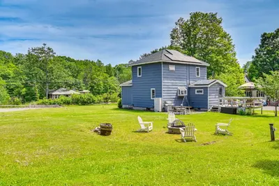 a large yard with chairs and a blue house at Charming Catskills Getaway Hike, Bike, Sip and More in Acra