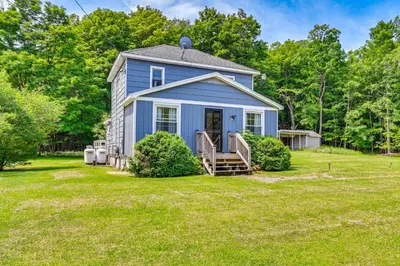 a blue house in the middle of a yard at Charming Catskills Getaway Hike, Bike, Sip and More in Acra