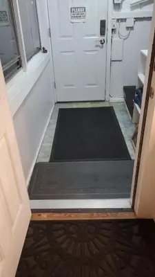 an open door with a black mat in front of a door at The Fred Deluxe 7 BR by I95 Train HarborVw Beach in Stamford