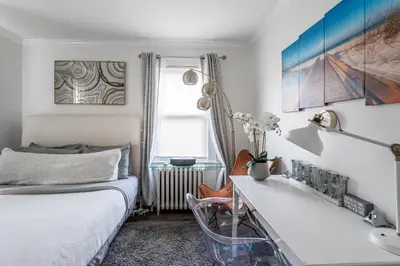 a bedroom with a bed and a desk with a sink at The Fred Deluxe 7 BR by I95 Train HarborVw Beach in Stamford