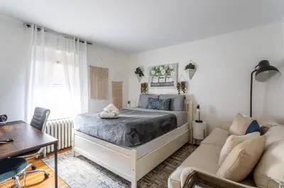 a bedroom with a bed and a couch at The Fred Deluxe 7 BR by I95 Train HarborVw Beach in Stamford