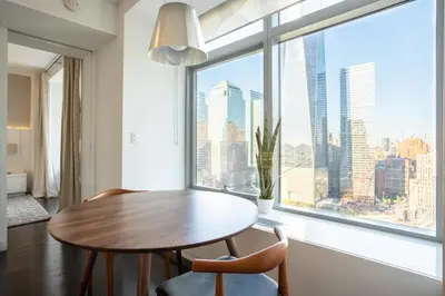 a dining room with a table and chairs and a large window at Tribeca 1br w doorman gym roof deck NYC-1374 in New York