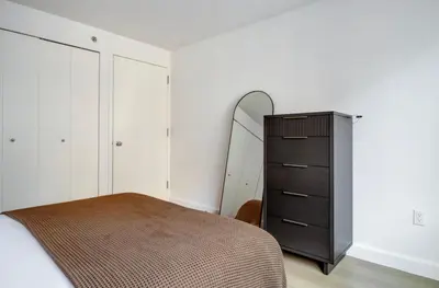 a bedroom with a bed and a dresser and a mirror at Chelsea 1br w roofdeck gym nr Flatiron NYC-1384 in New York