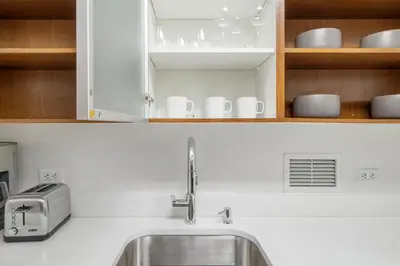 a kitchen with a sink and cups and cabinets at Chelsea 1br w roofdeck gym nr Flatiron NYC-1384 in New York
