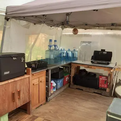 a kitchen in a tent with a table and a stove at Tentrr Riverfront Ritz in Lake Luzerne