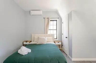 a bedroom with a green bed with two towels on it at Modern 3 Bed House in Black Rock in Bridgeport