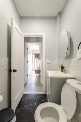 a white bathroom with a toilet and a sink at Modern 3 Bed House in Black Rock in Bridgeport
