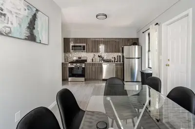 a kitchen with a glass table and black chairs at Modern 3 Bed House in Black Rock in Bridgeport