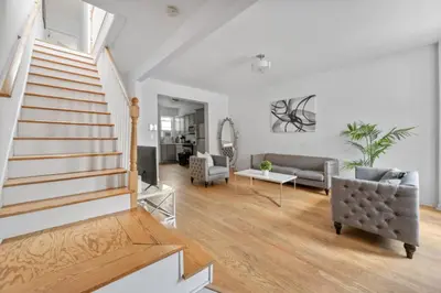 a living room with a staircase and a couch at Modern Home 4BR 3BA - 20 Min to Timesquare in Jersey City