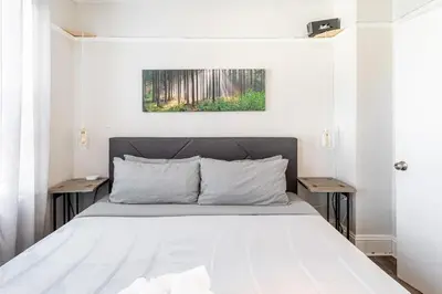 a white bedroom with a bed with two tables at Spacious&Gracious- 5BR Fam-Friendly near I95&Shops in Fairfield