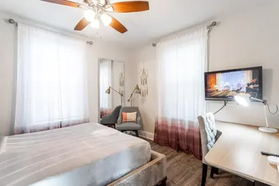 a bedroom with a bed and a desk and a tv at Spacious&Gracious- 5BR Fam-Friendly near I95&Shops in Fairfield