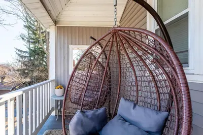 a wicker swing on a porch with blue pillows at Spacious&Gracious- 5BR Fam-Friendly near I95&Shops in Fairfield