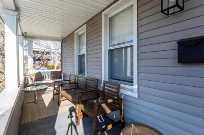 a porch with two chairs on a house at Spacious&Gracious- 5BR Fam-Friendly near I95&Shops in Fairfield