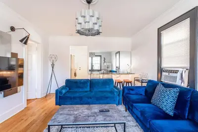 a living room with a blue couch and a table at The B&W Haven 5BR Home with yard theater in Bridgeport