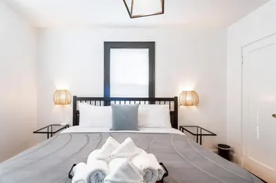 a bedroom with a large bed with two lamps at The B&W Haven 5BR Home with yard theater in Bridgeport