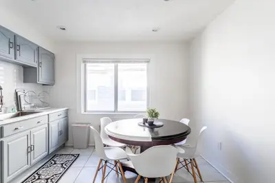 a kitchen with a round table and white chairs at The B&W Haven 5BR Home with yard theater in Bridgeport