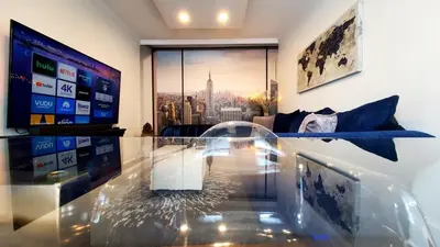 a living room with a glass table and a tv at Modern 3BR Apartment Downtown HarborPt I-95 Train in Stamford