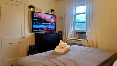 a bedroom with a bed with a tv on the wall at Modern 3BR Apartment Downtown HarborPt I-95 Train in Stamford