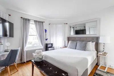 a bedroom with a bed and a desk and a chair at Sunshine Room by harbor downtown beach I-95&Train in Stamford